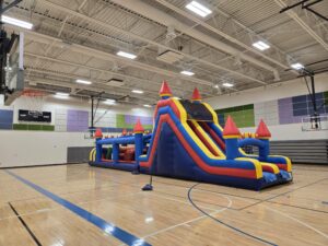 Massive inflatable obstacle course with slide set up in Omaha gym – Omaha bounce house delivery by Jumpers4You
