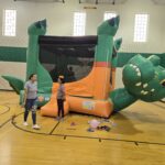 Crocodile bounce house setup in a gym by Jumpers4You – Omaha bounce house delivery