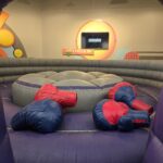 Giant inflatable boxing gloves on the arena floor – Jumpers4You Omaha bounce house delivery setup