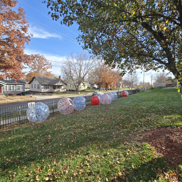 HOA and Block Party Rentals Omaha – inflatable bubble balls lined up along a neighborhood sidewalk