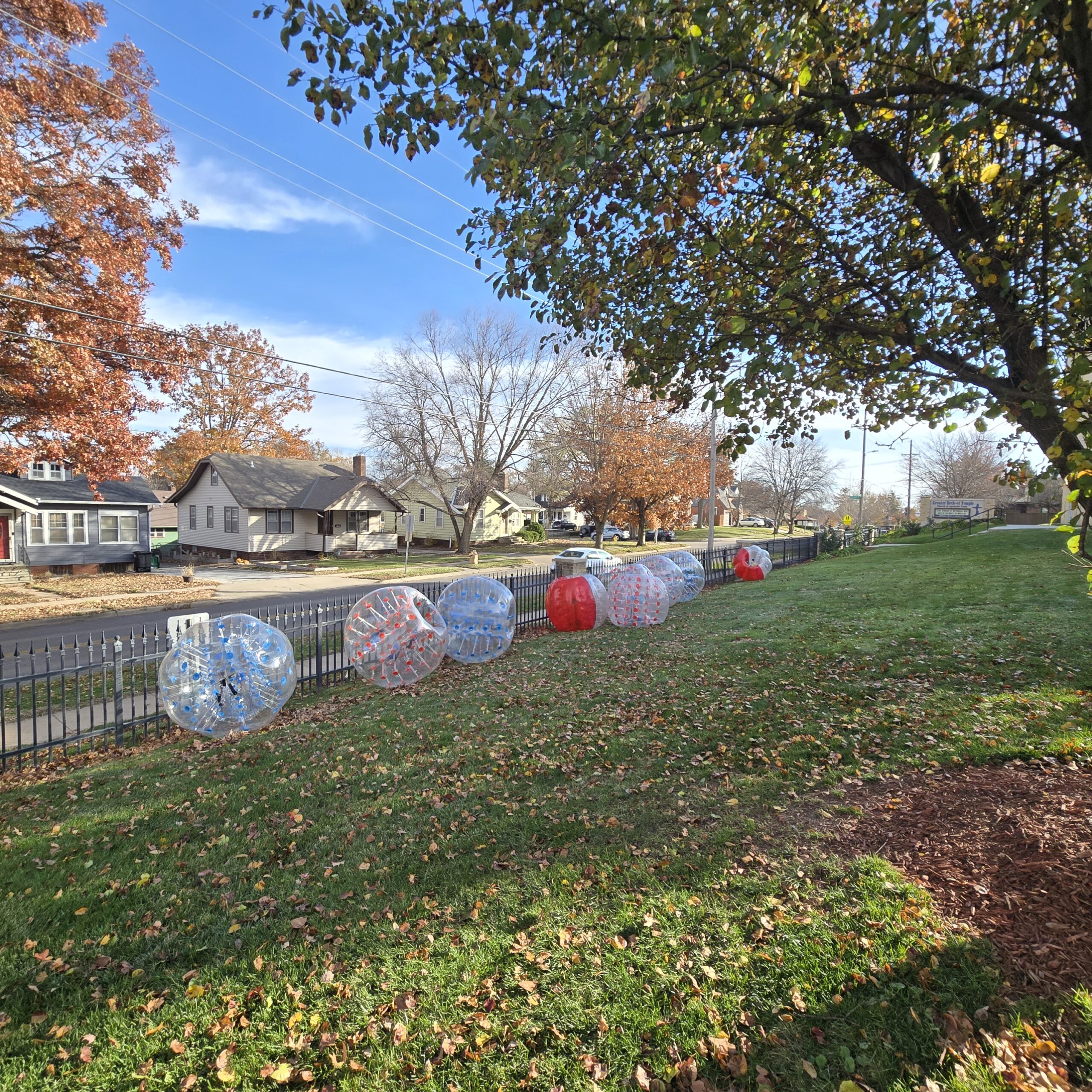 Clear and colorful inflatable bubble balls lined along a neighborhood sidewalk