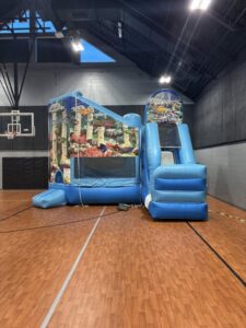 Indoor bounce house setup in Omaha gymnasium with ocean theme combo unit – Omaha bounce house delivery