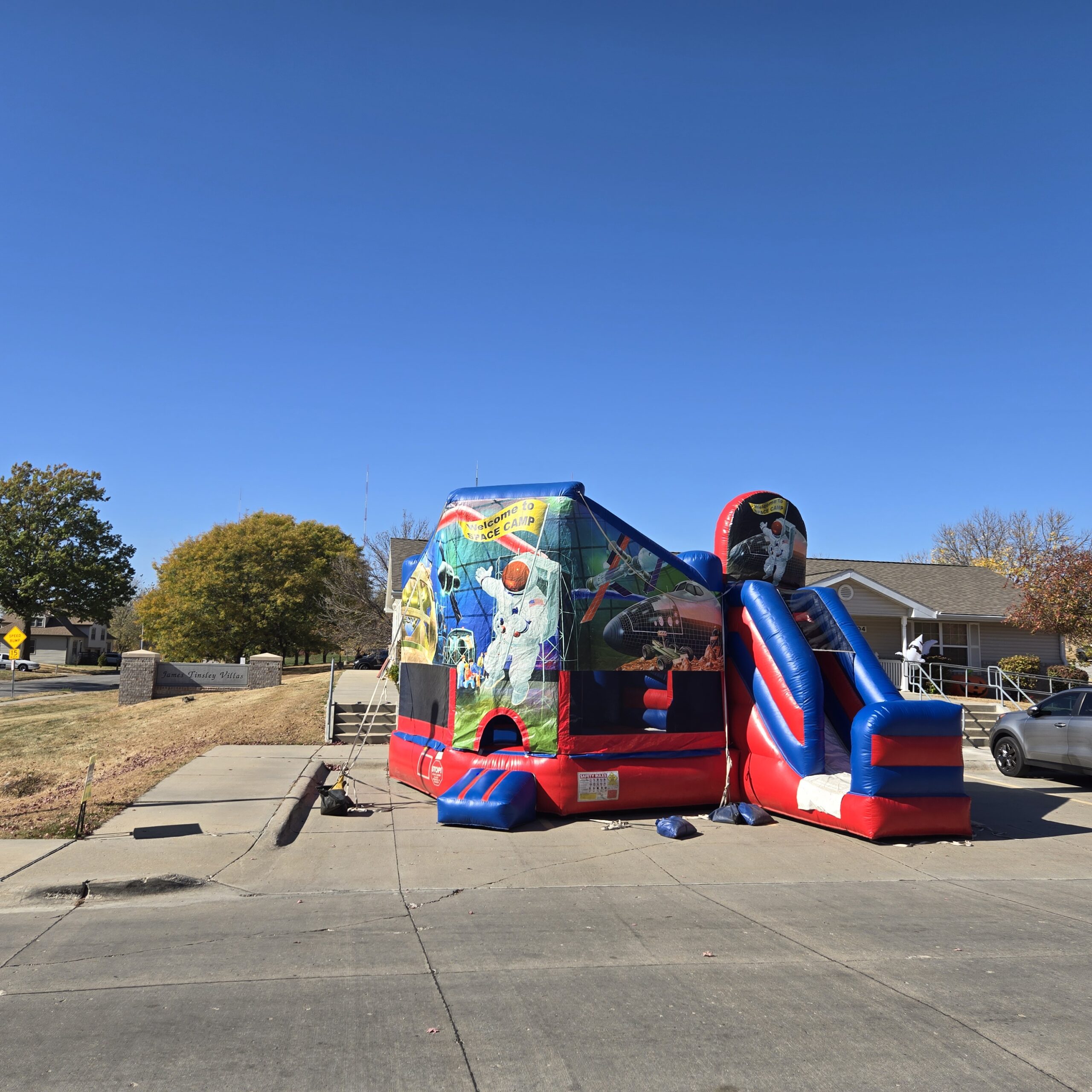 Space-themed bounce house combination unit with an attached inflatable slide